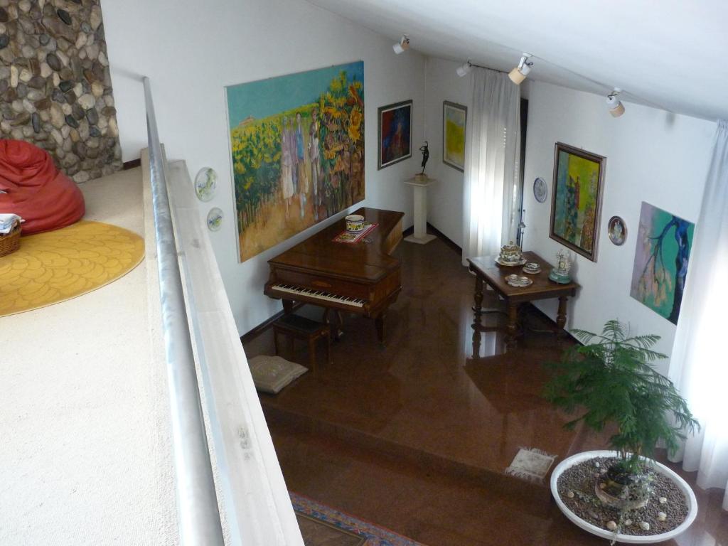 a living room with a piano and paintings on the walls at B&B Cà d'Artisti in Caorle