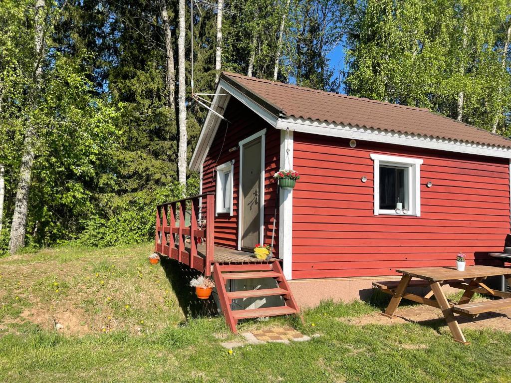 una cabaña roja con una mesa de picnic delante de ella en puhkemajake, en Rõuge