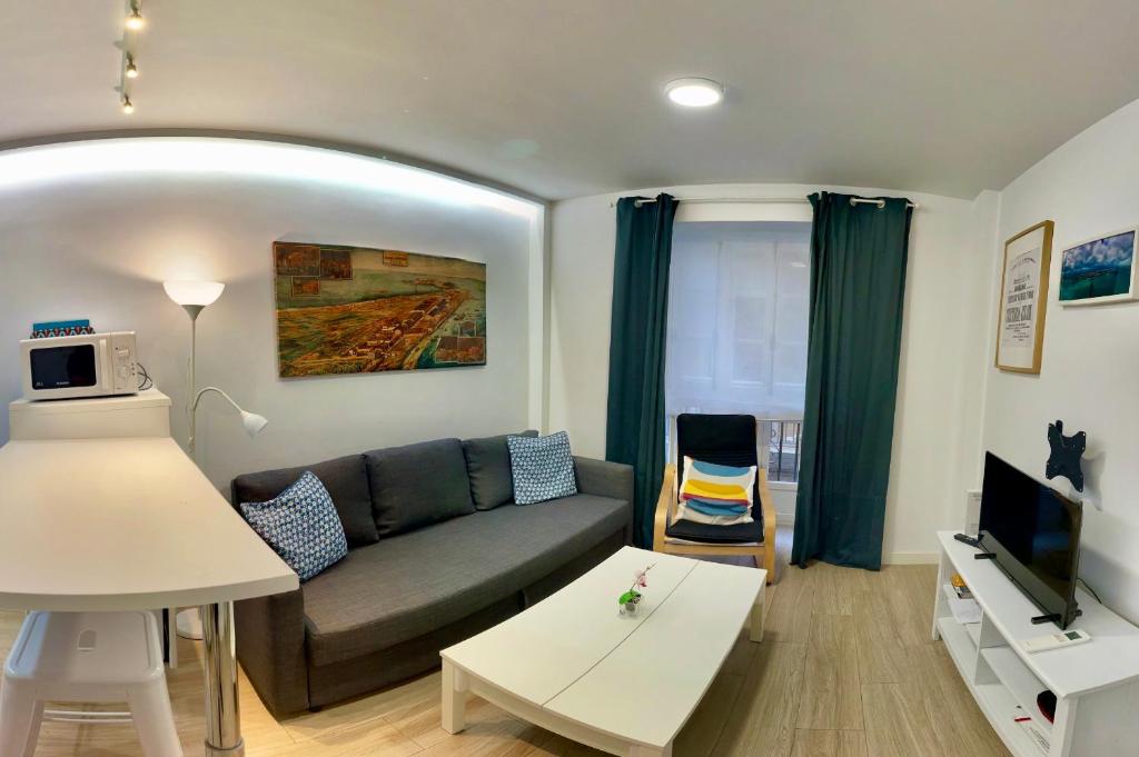 ein Wohnzimmer mit einem Sofa und einem TV in der Unterkunft Alameda apodaca in Cádiz