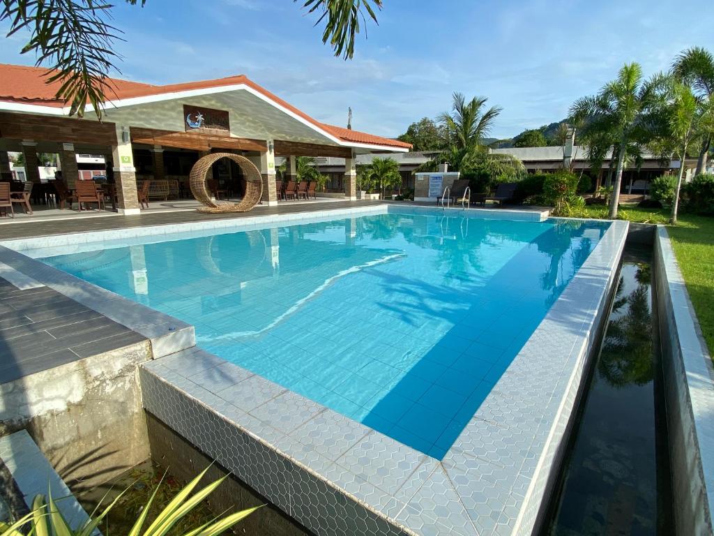 une grande piscine d'eau bleue dans l'établissement RSAM Beach Resort by Cocotel, à Nasugbu