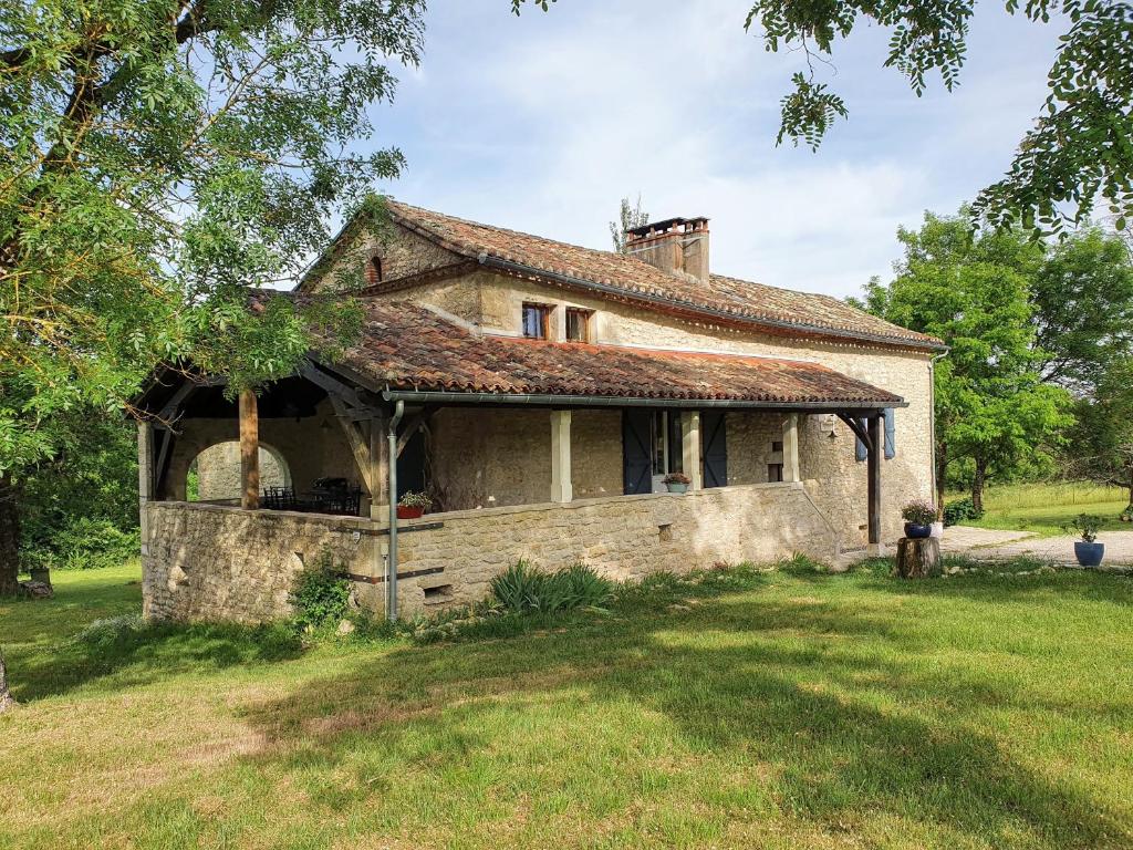 een oud stenen huis in een grasveld bij La Quintarde in Flaujac-Poujols
