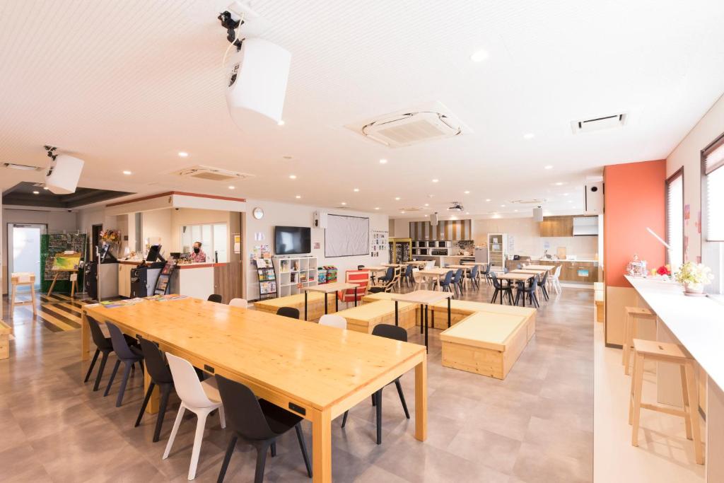 a kitchen and dining room with tables and chairs at Wild Cherry Blossom-HOSTEL,TOKYO KOGANEI- in Koganei