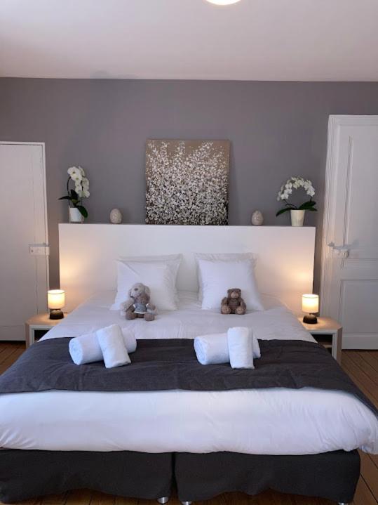 2 ours en peluche assis au-dessus d'un grand lit dans l'établissement Gite Chez Livia Hautes Vosges, à Bruyères