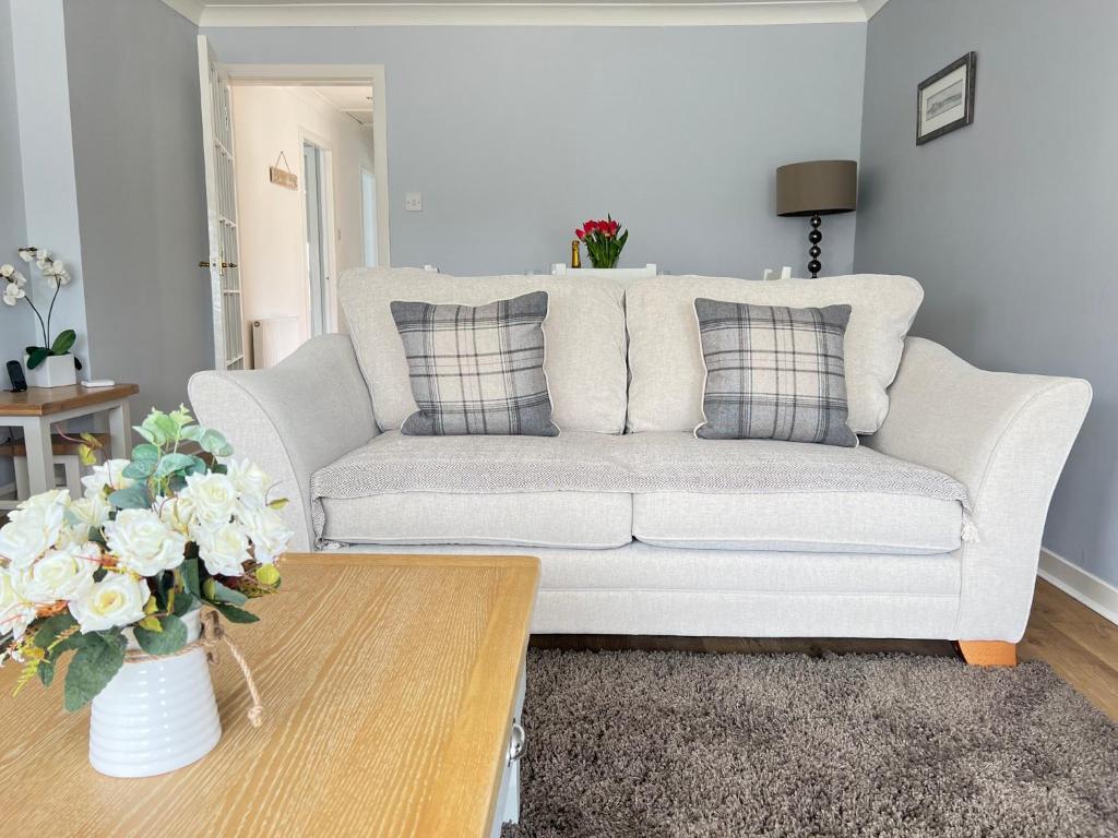 a living room with a couch and a coffee table at Dragonfly - HOT TUB luxury two bedroom cottage in Cellardyke