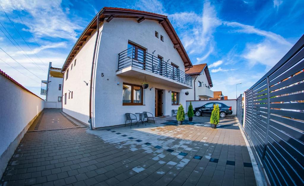 una casa bianca con un'auto parcheggiata nel vialetto di Five House a Sibiu