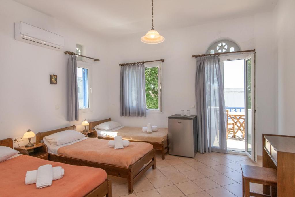 ein Hotelzimmer mit 2 Betten und einem Balkon in der Unterkunft Esperides in Tinos