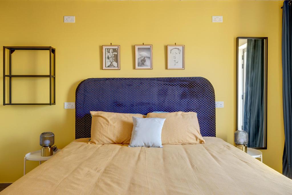 a bedroom with a large bed with a blue headboard at Sliema Creek Suites in Sliema