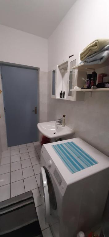 a bathroom with a sink and a washing machine at Apartment Pijer in Novalja