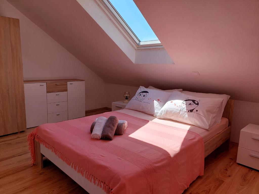 Schlafzimmer mit einem großen Bett und einem Dachfenster in der Unterkunft Apartmani Timon in Bol