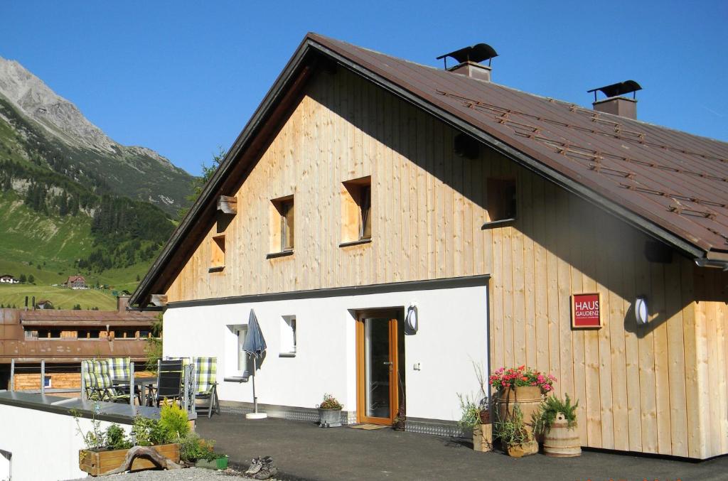 a large white building with a brown roof at Haus Gaudenz in Warth am Arlberg