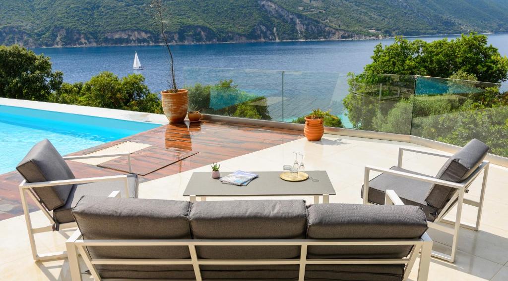 a patio with a table and chairs and a view of the water at Villa Thilia in Meganisi
