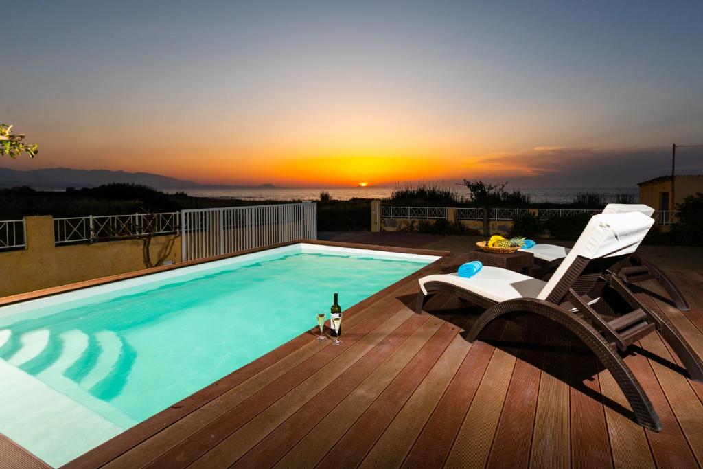 - une piscine avec une chaise et une bouteille de vin dans l'établissement Bella Vista House, à Magnisía