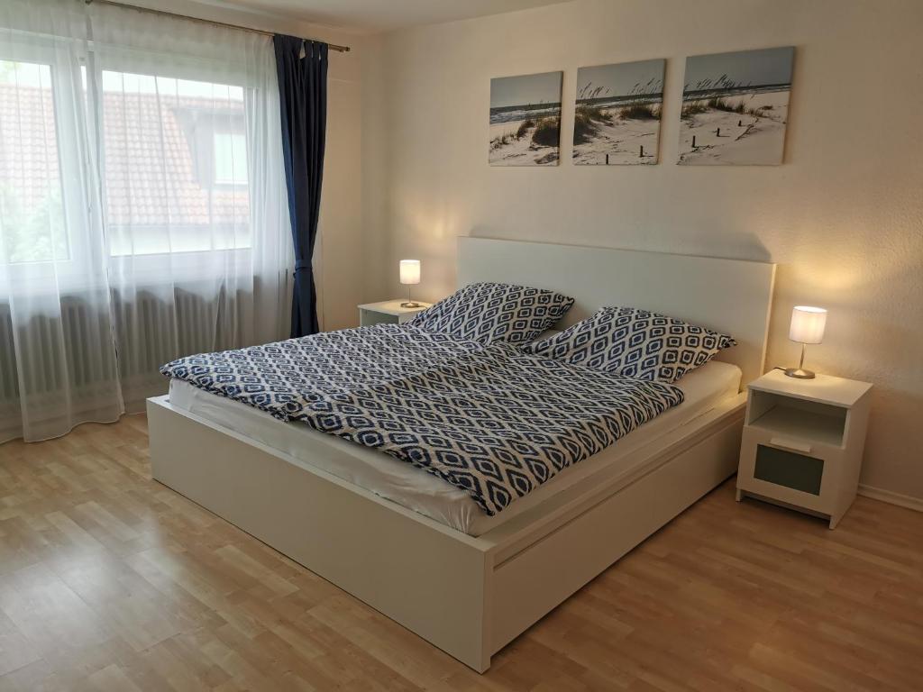 um quarto com uma cama, 2 candeeiros e uma janela em Ferienwohnung im Deggenhausertal em Deggenhausertal