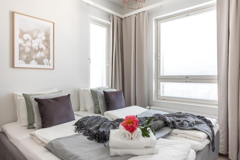 um quarto com uma grande cama branca com uma flor em Arctic Penthouse City Suite em Rovaniemi