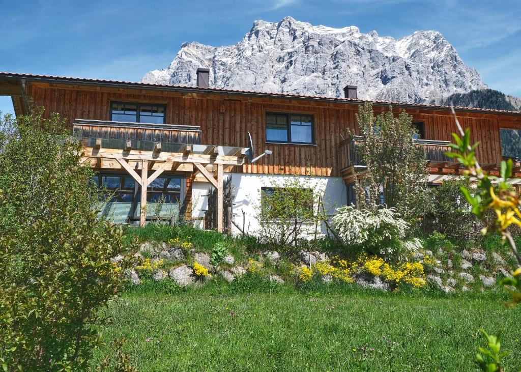 una casa de madera con una montaña en el fondo en Haus Lorea Ehrwald, en Ehrwald