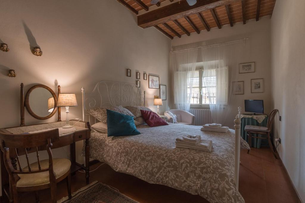 a bedroom with a bed with a desk and a mirror at B&B Arivellini in Vicopisano