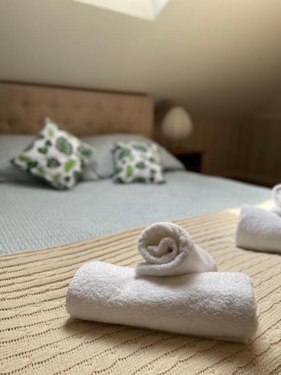 a pile of towels sitting on top of a bed at Restauracja Rozmarzyn in Ostrzeszów