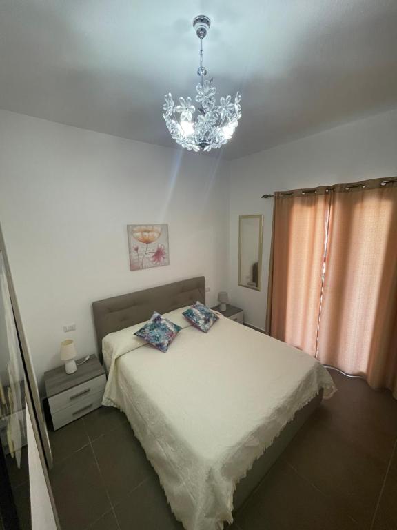 um quarto com uma cama e um lustre em Stella Marina em La Caletta