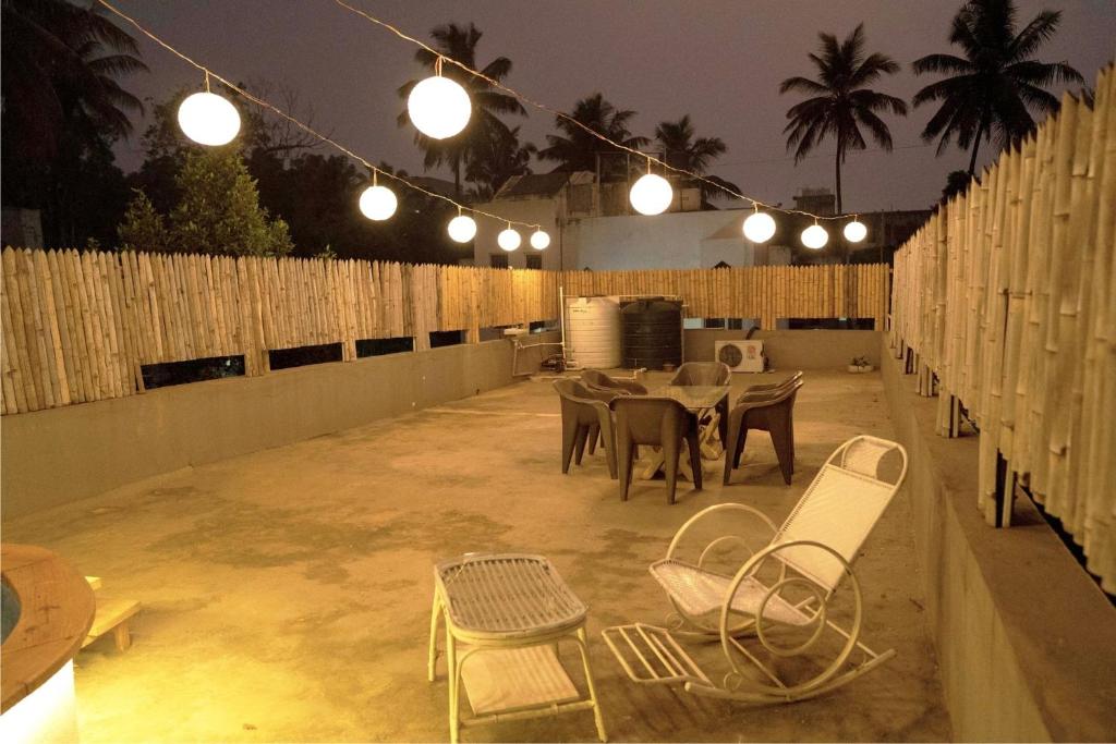 a patio with a table and chairs and lights at The Cottage - by Chandralok Homestays in Kolhapur