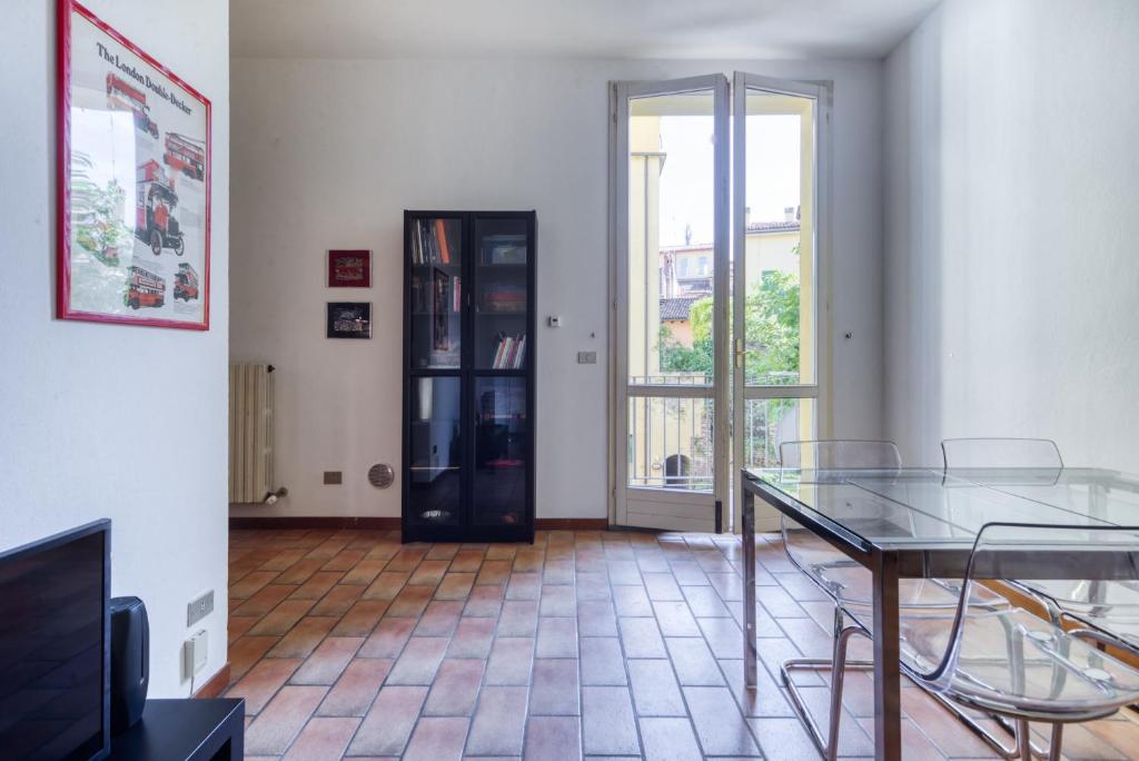 a dining room with a glass table and chairs at Castiglione Family Apartment by Wonderful Italy in Bologna