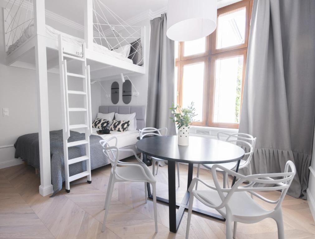 a room with a table and chairs and a bunk bed at Homewell Apartments Wilson Park II in Poznań