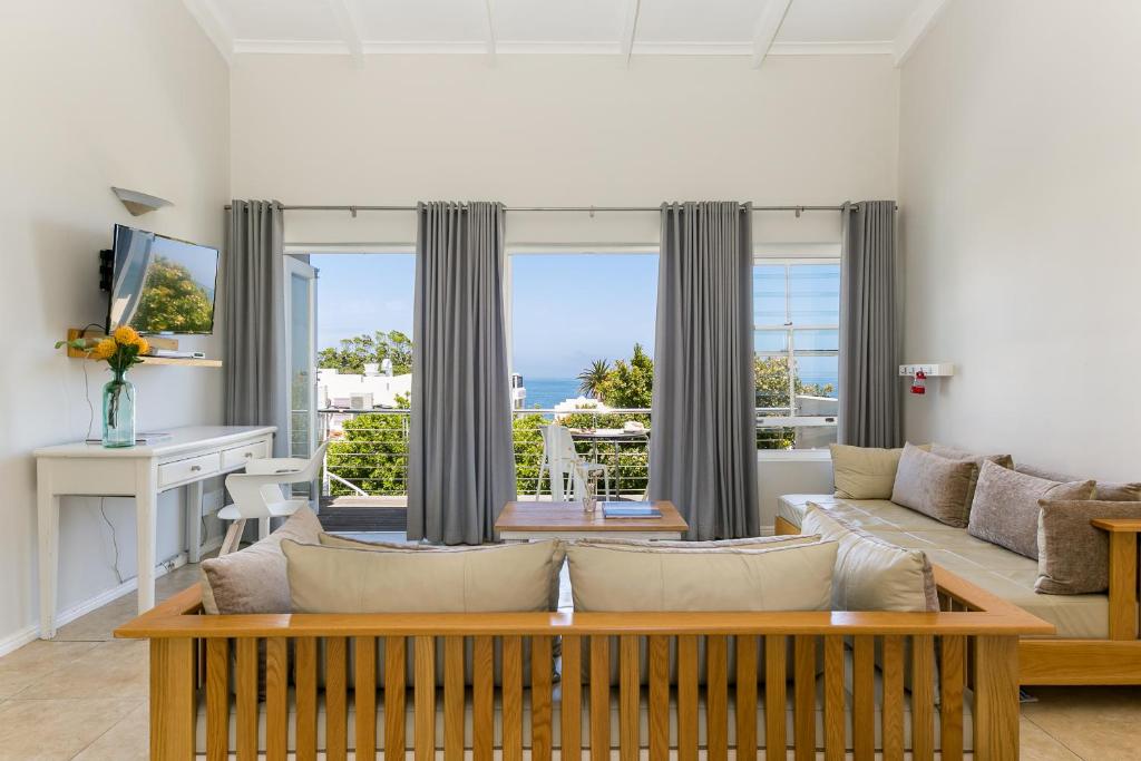 a living room with a couch and a table at Camps Bay Village - Beach Studios in Cape Town
