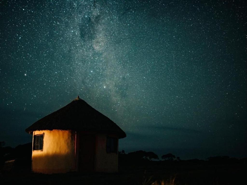 un petit bâtiment sous un ciel étoilé la nuit dans l'établissement Bulungula Xhosa Community Lodge, à Bulungulu