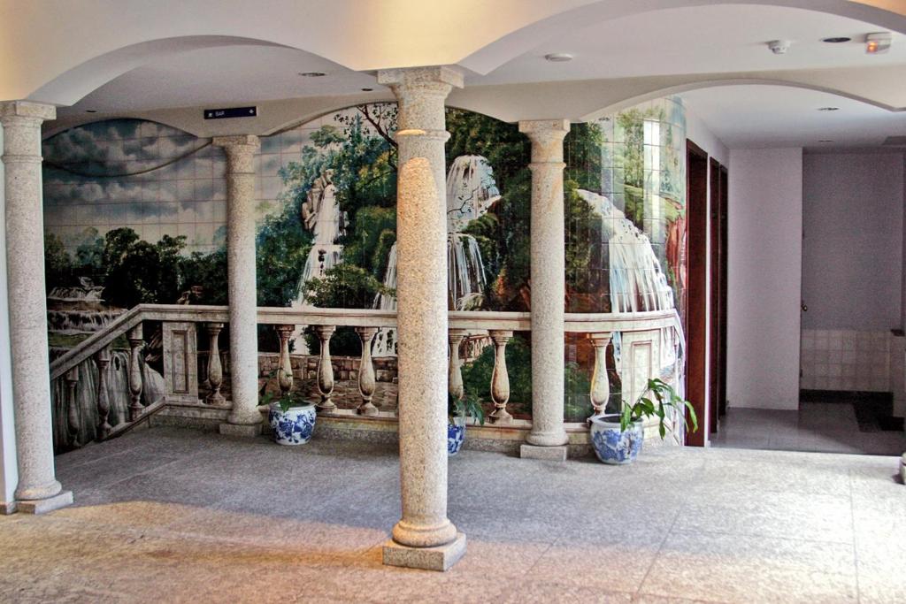 a mural in a building with columns at Casa de Retiros N. S. Perpetuo Socorro in Guimarães