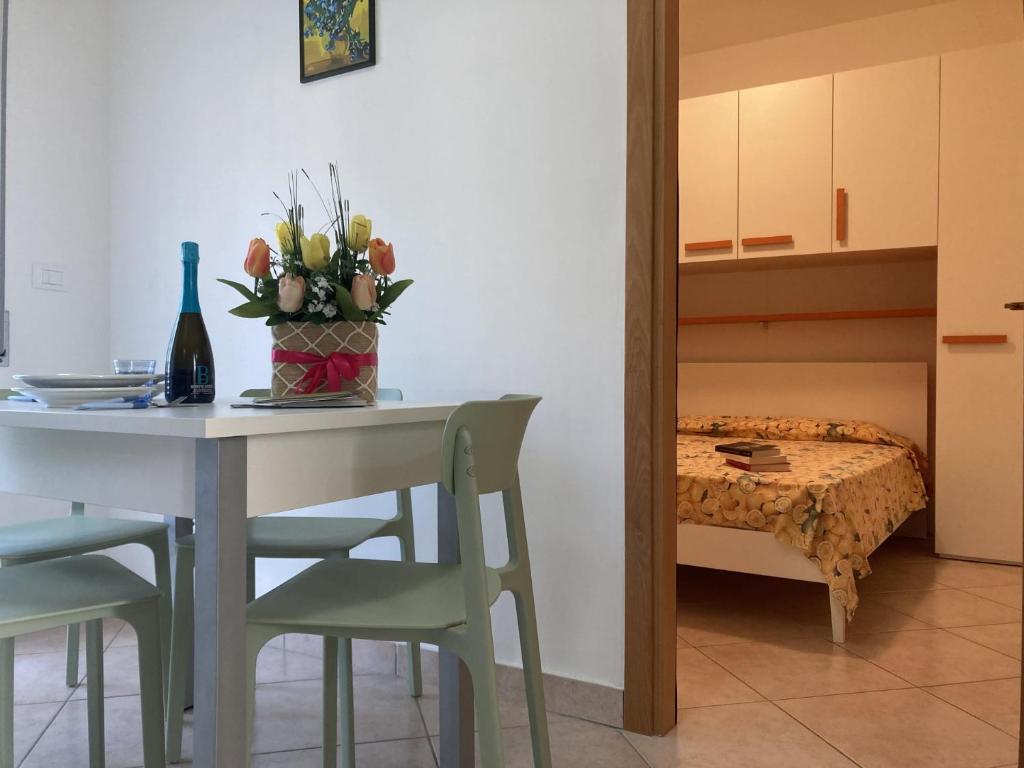 ein Tisch und Stühle mit einer Blumenvase drauf in der Unterkunft Milady in Rosolina Mare
