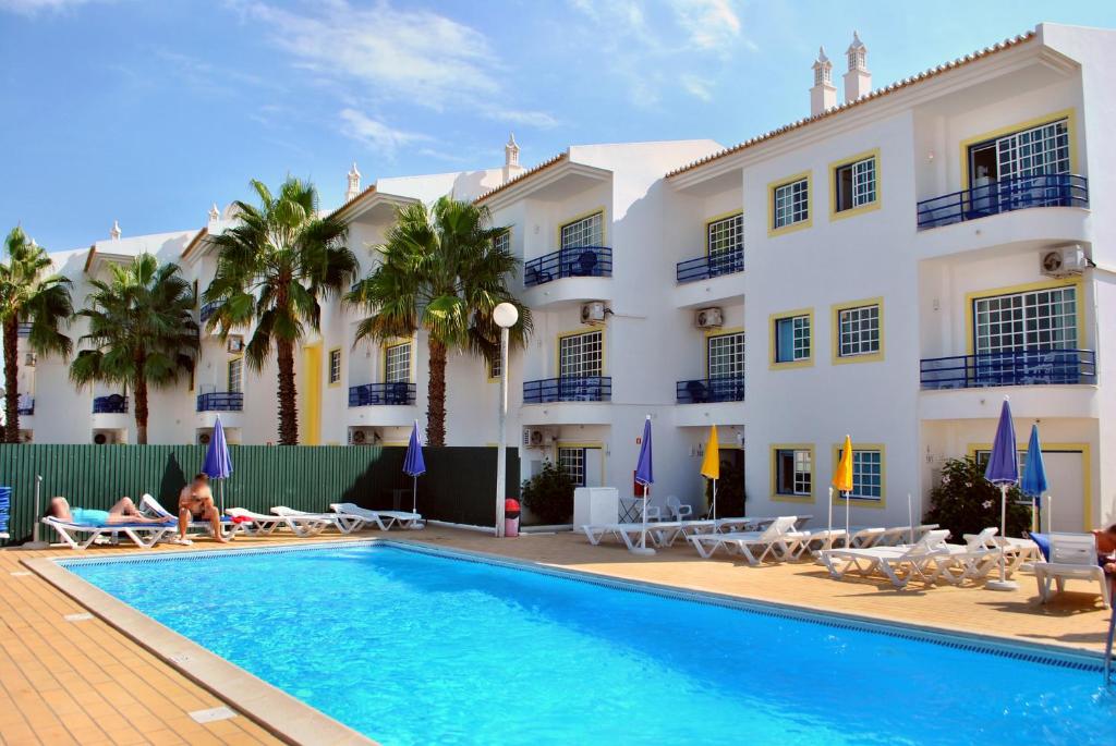 a hotel with a swimming pool in front of a building at Apartamentos Sereia da Oura in Albufeira