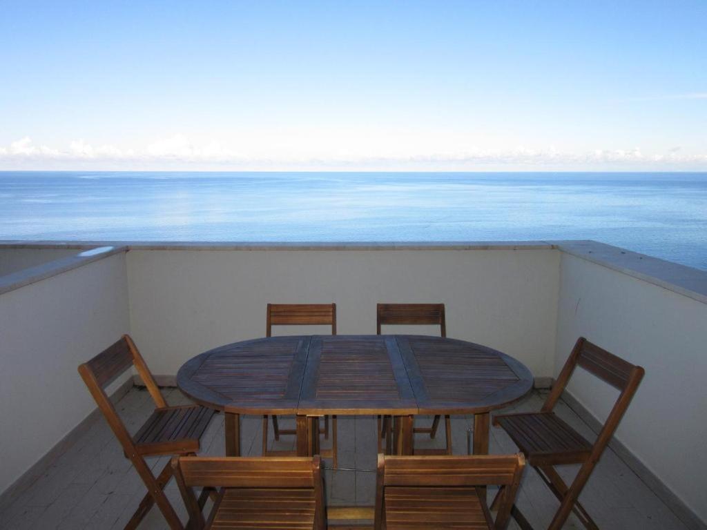 a table and chairs on a balcony with the ocean at Appartamento Tramonto in Castelsardo