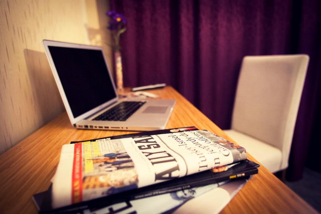 a book sitting on a table with a laptop computer at Helikon Business Hotel in Istanbul