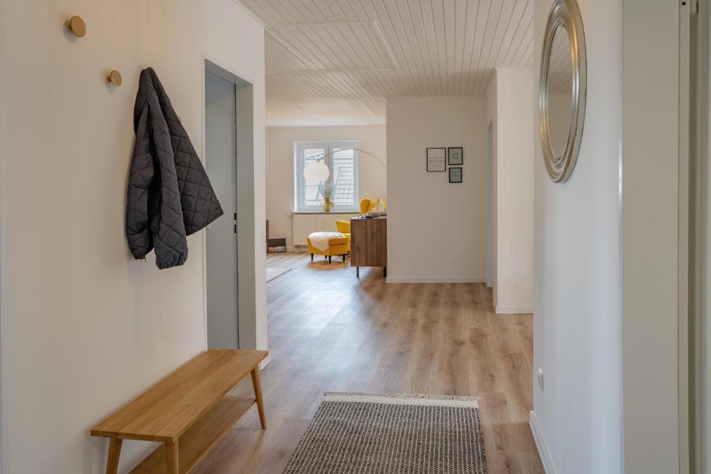 sala de estar con paredes blancas y suelo de madera. en Ferienwohnung meer.pause im Herzen von Grömitz, en Grömitz