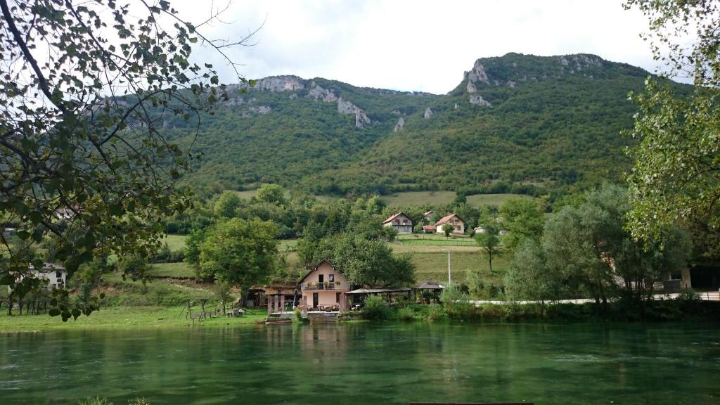 a house on the river with mountains in the background at Bed and Breakfast Family Djukic in Šipovo