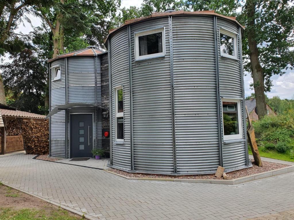 a large metal house sitting on top of a driveway at Ferienhaus Getreidesilo in Schneverdingen