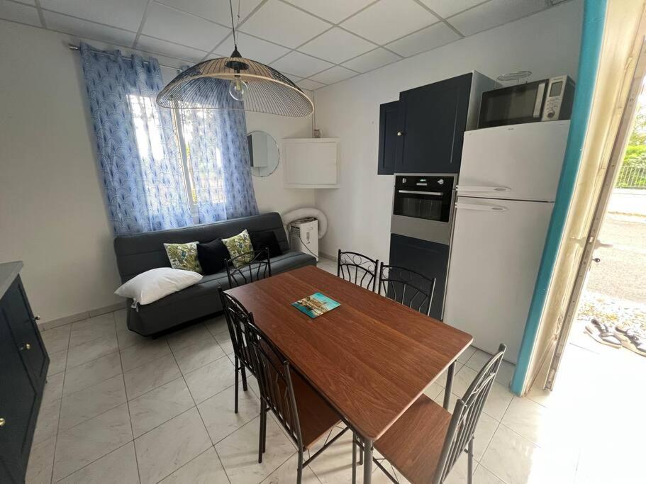 a kitchen and living room with a table and a couch at Appartement en face de la plage avec barbecue in Plage dʼArgelès