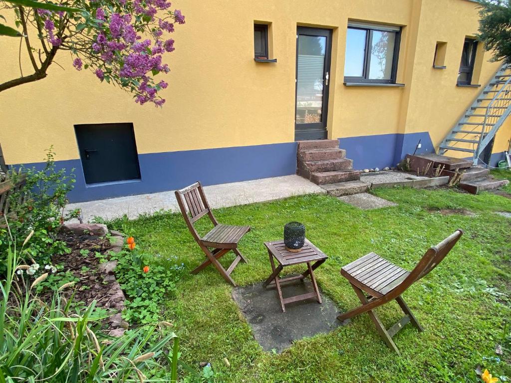 einen Hof mit zwei Stühlen, einem Tisch und einem Gebäude in der Unterkunft Talblick in Straubenhardt