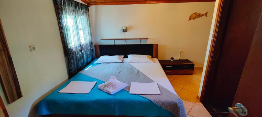 a bedroom with a blue bed with two towels on it at Dalis House in Astris