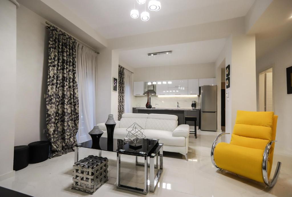 een woonkamer met een witte bank en een gele stoel bij Erythrina #colony_deluxe_suite in Thessaloniki