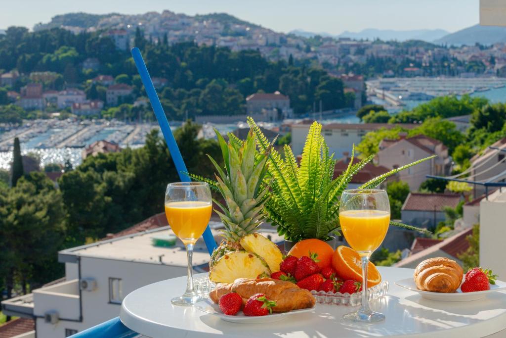 una mesa con fruta y dos vasos de zumo de naranja en Apartment Sunset free parking en Dubrovnik