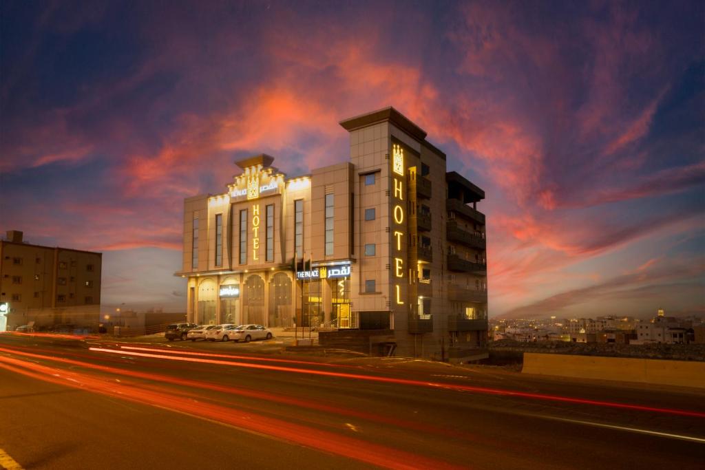 a building on a city street with a cloudy sky at The Palace Hotel Suites in Khamis Mushayt
