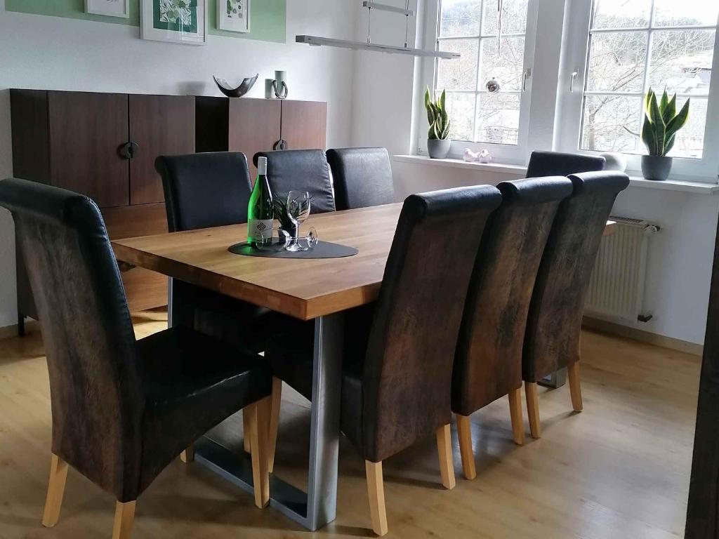 una mesa de comedor con sillas negras alrededor en Ferienhaus Weitblick, en Eslohe