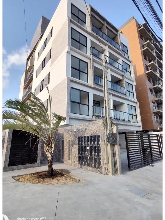 uma palmeira em frente a um edifício em Apartamento em Intermares a 100 metros do mar em Cabedelo