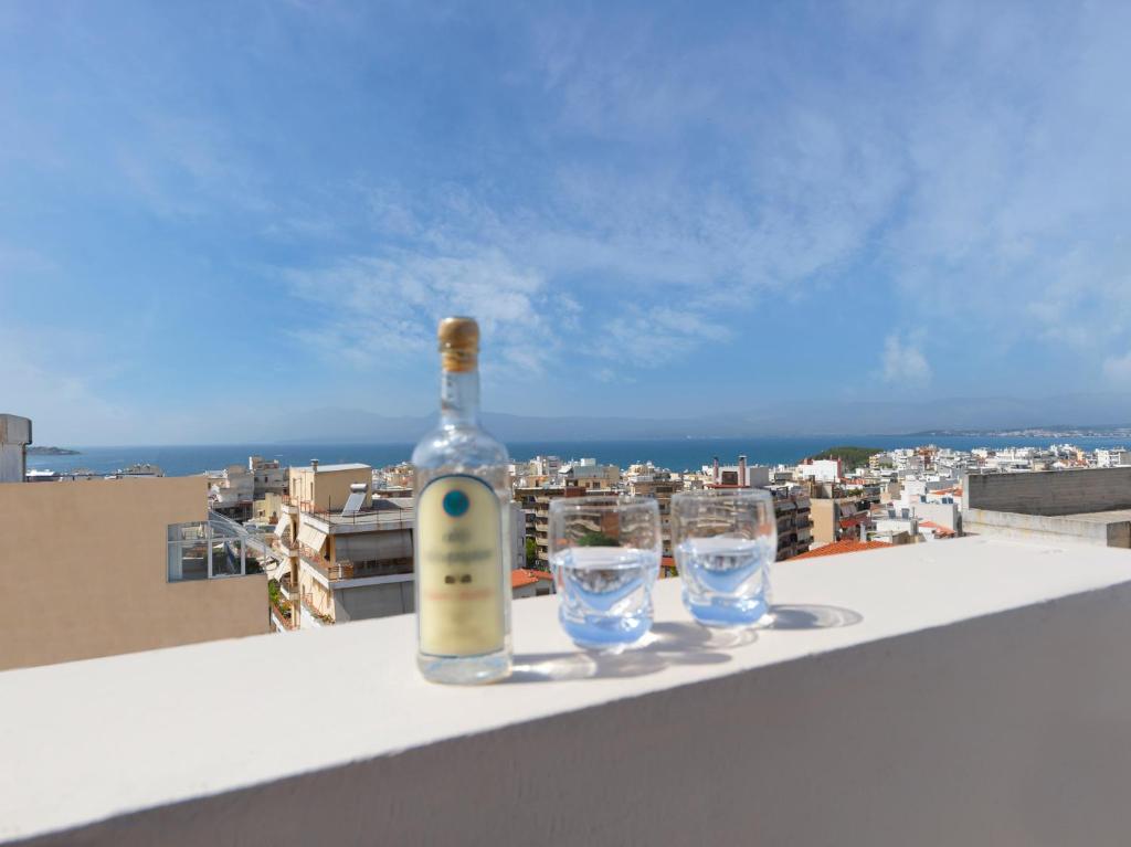 a bottle of wine and two glasses on a ledge at Modern Penthouse overlooking Halkis in Chalkida