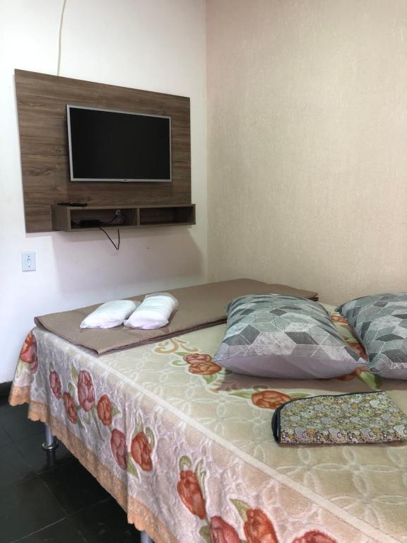 a bedroom with two beds and a tv on the wall at Flat Maricá II in Maricá