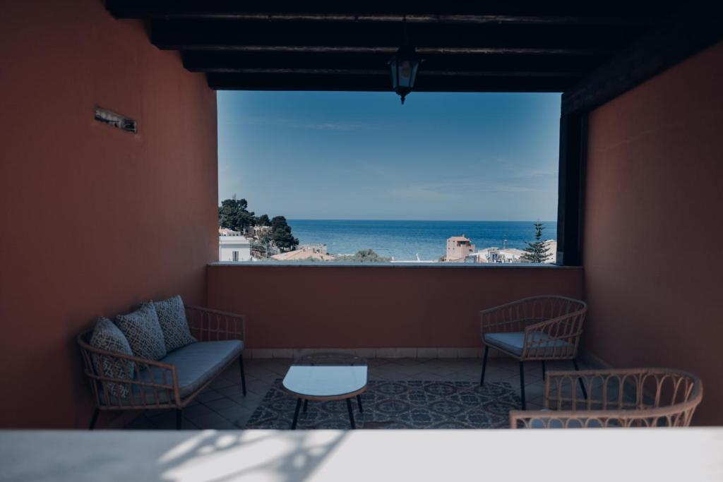 Habitación con mesa, sillas y vistas al océano. en Hotel Borgo di Ciàula, en Santa Flavia