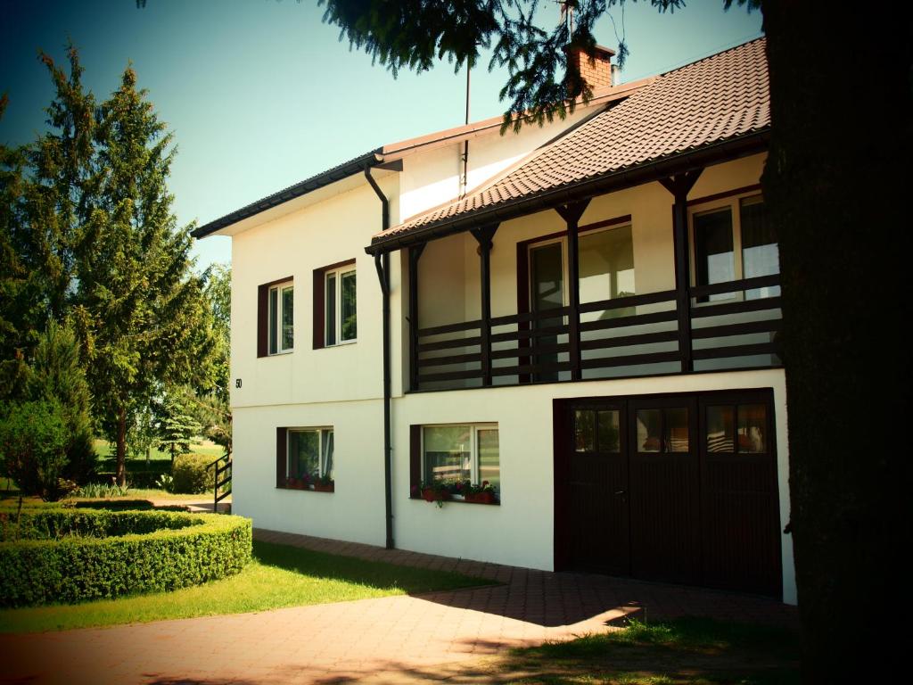 a large white house with a black garage at Biebrza 24 in Sztabin