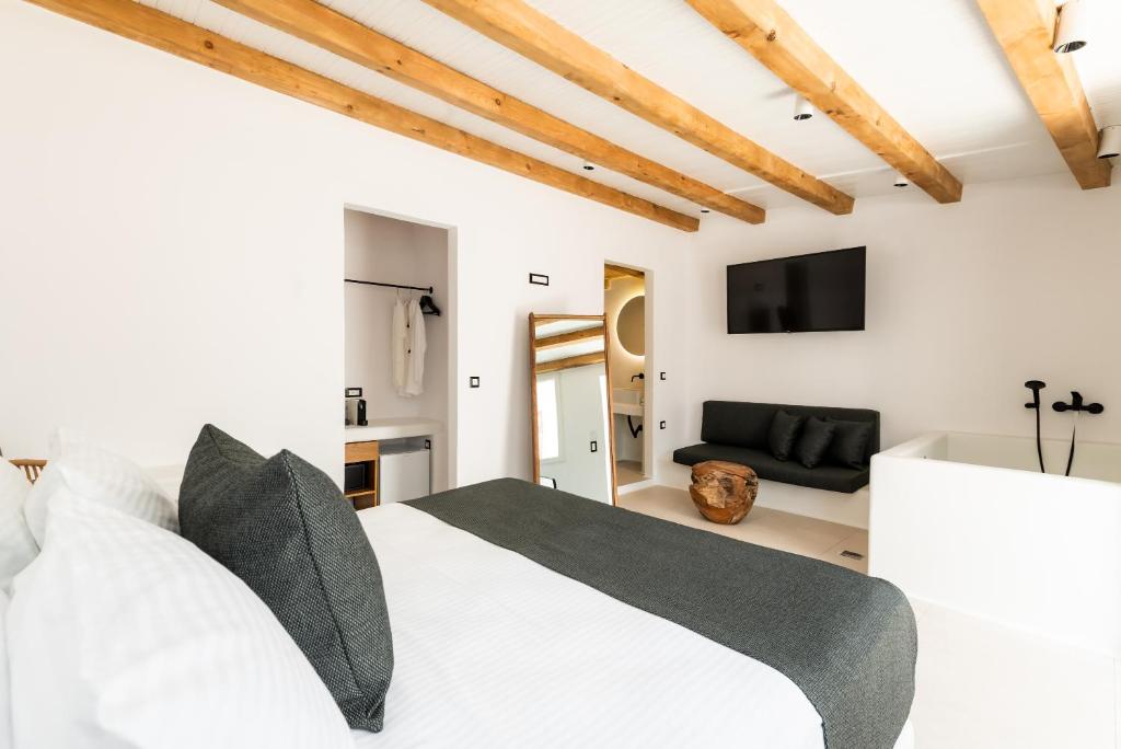 a bedroom with a white bed and a couch at Ryous Mykonos in Mikonos