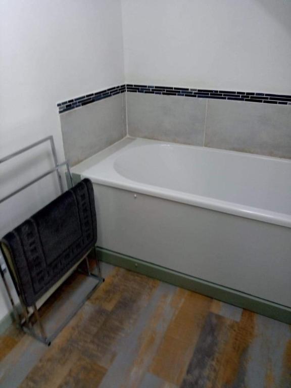 a white bath tub sitting in a room at Picturesque holiday cottage Britanny France in Treuscoat