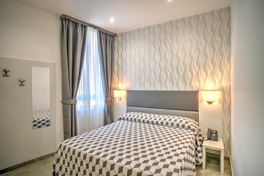 1 dormitorio con 1 cama con manta a cuadros en Hotel Porto Di Roma en Civitavecchia